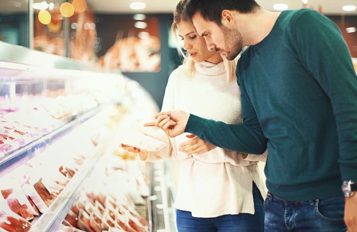 Couple looking at meat in supermarket